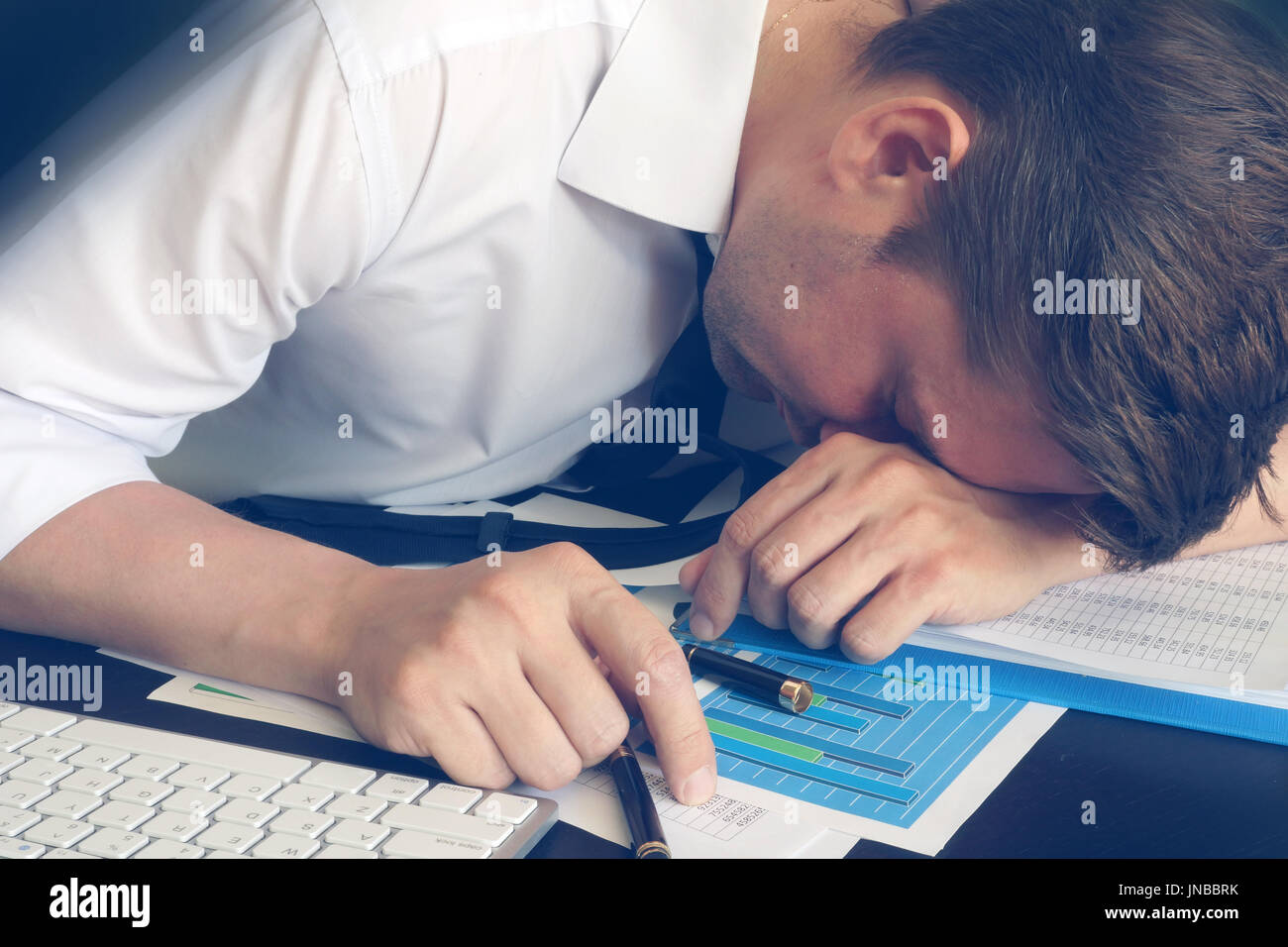 Syndrom der chronischen Müdigkeit. Überarbeitet Geschäftsmann schläft am Schreibtisch. Stockfoto