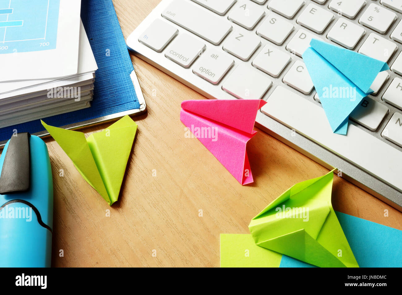 Procrastination Konzept. Bunte Papier Flugzeuge auf einem Büro Tisch. Stockfoto