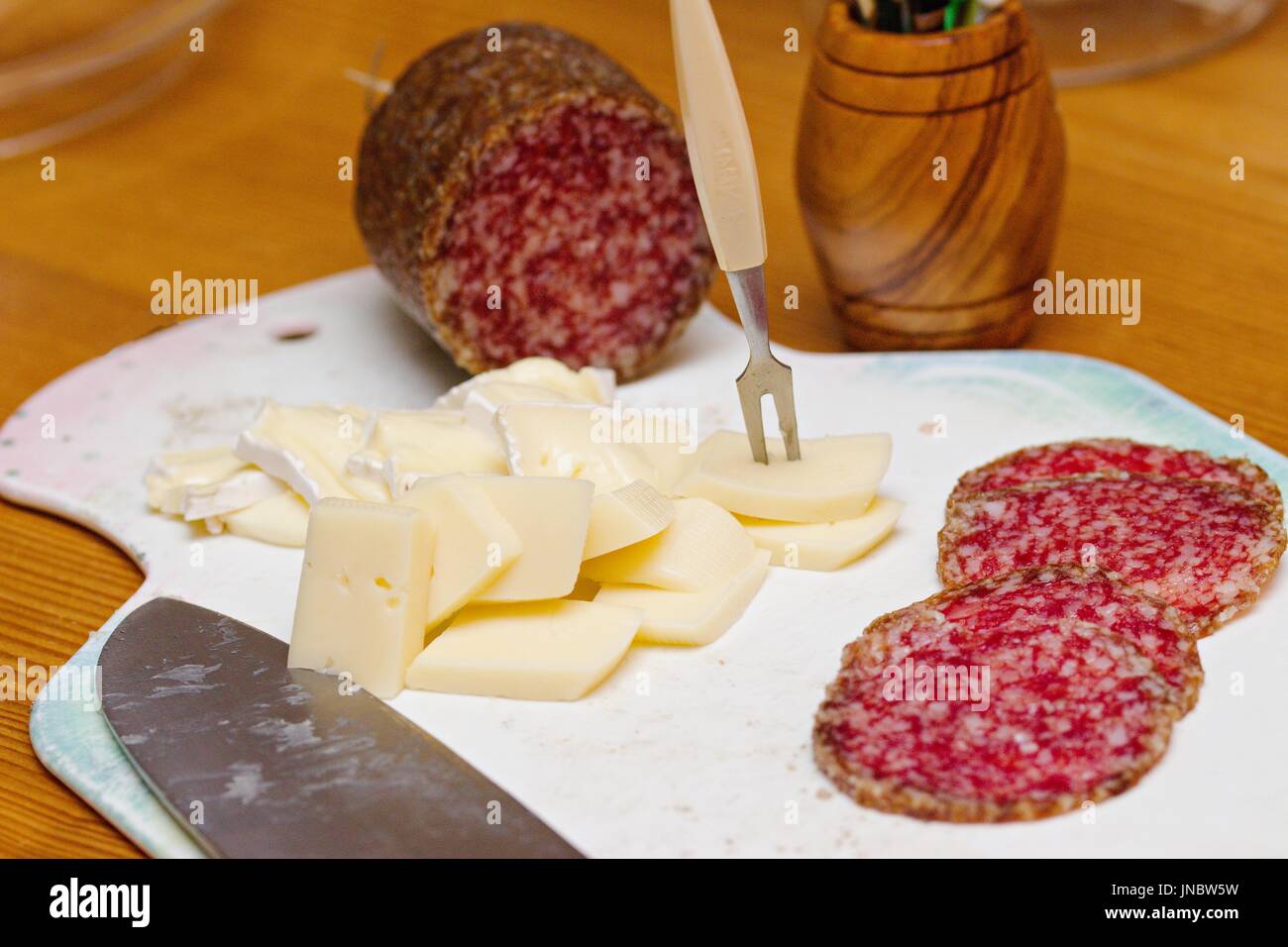 Heimatpartei Vorspeise - Gourmet-Käse und Salami auf weiß gut genutzt, Schneidebrett Stockfoto