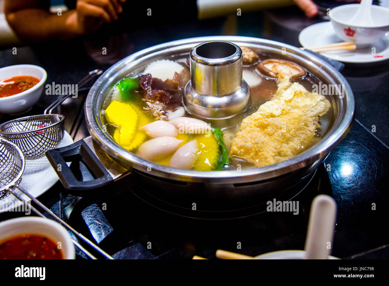 Thai hotpot (Tom Yum Suppe) in einem Restaurant, das Essen am Tisch gekocht Stockfoto
