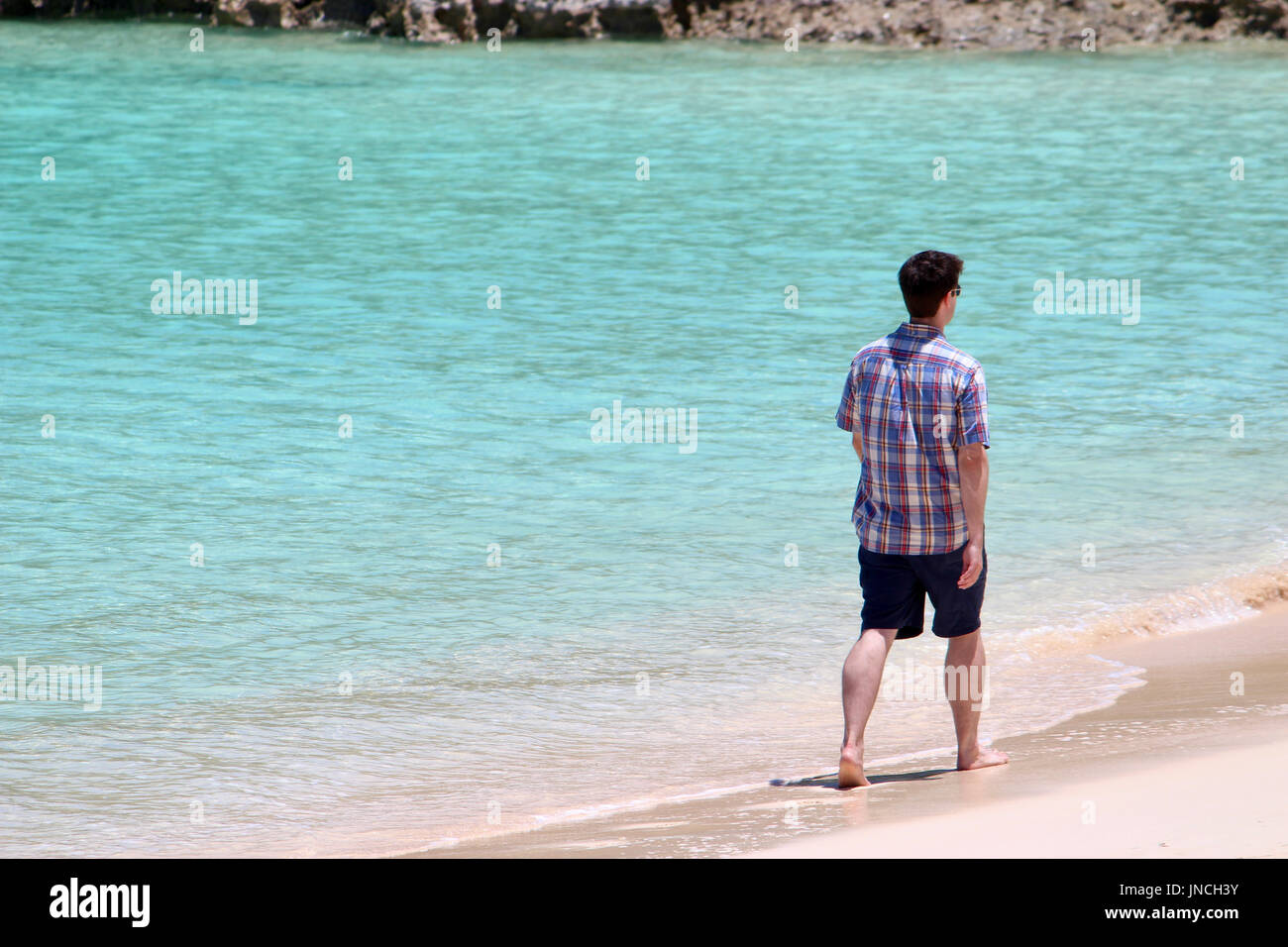 Ein Mann geht an einem Strand in Bermuda Stockfoto