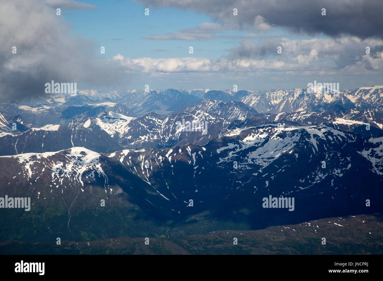 Gebrochen Kumuluswolke gesehen von oben nach unten über Berggipfel, Fjorde im Westen in der Nähe von Tromsø Stockfoto