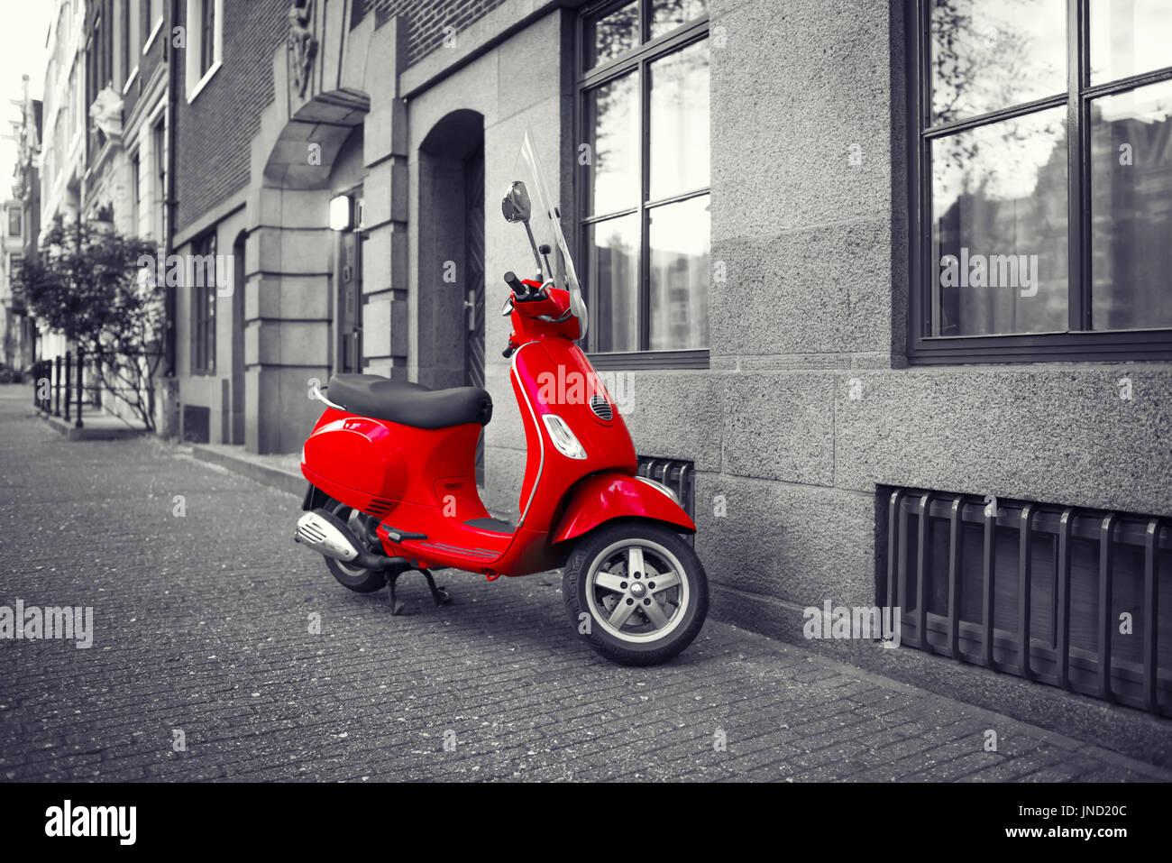 Rote Vintage Roller auf Bürgersteig der leeren Stadt Straße geparkt. Selektive Farbkorrektur-Effekt Stockfoto