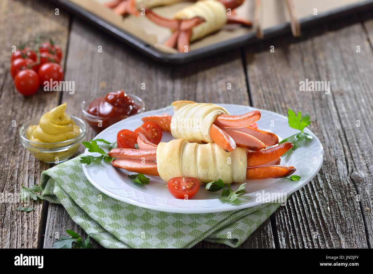 Gebackene Wiener Würstchen umhüllt mit Blätterteig frisch aus dem Ofen, oft als ein Kindermenü serviert Stockfoto
