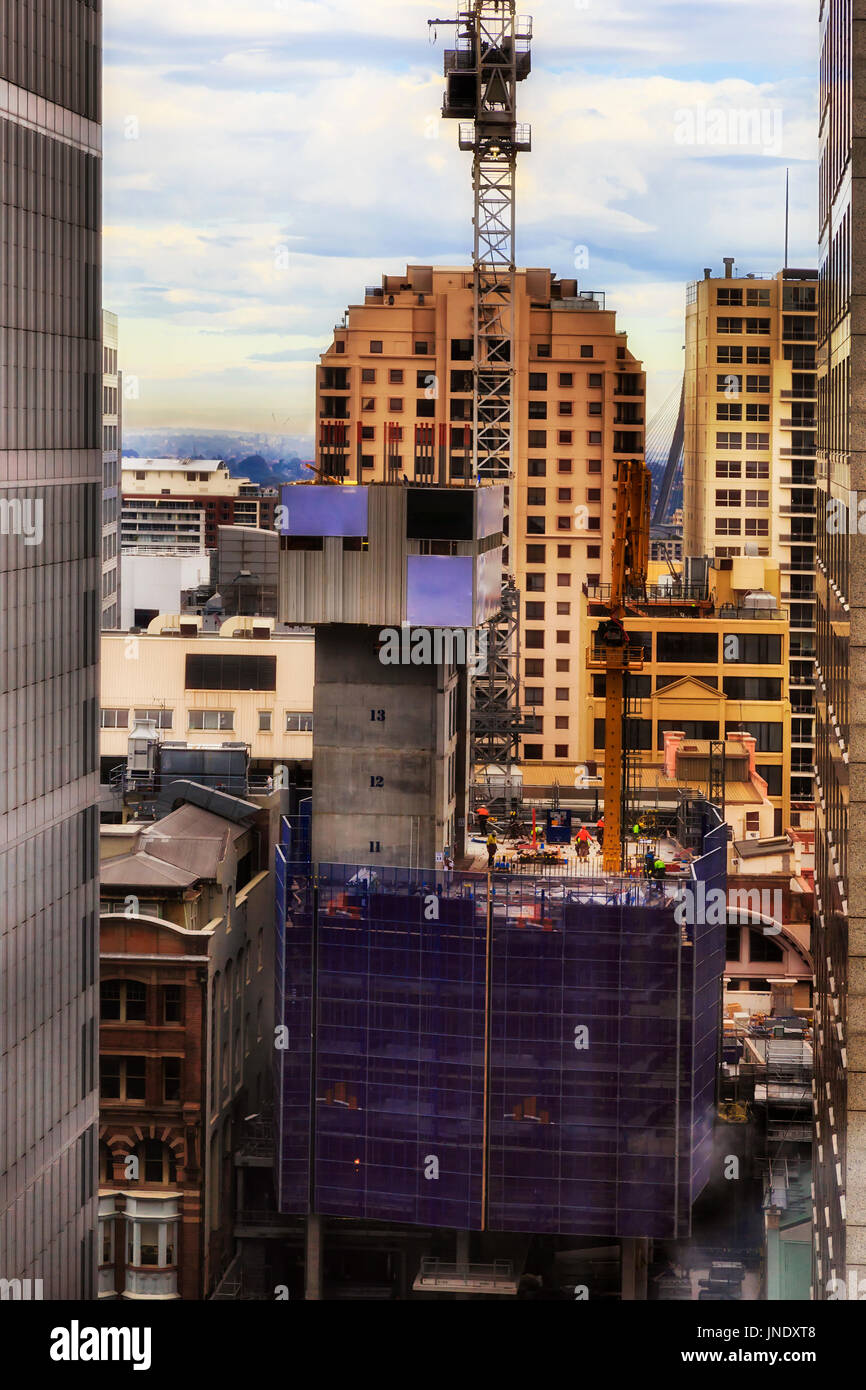 Baustelle der steigenden Wolkenkratzer Gebäude Stadt Sydney CBD. Handwerker-Arbeitnehmer bei der Arbeit mit Baumaschinen, Schwertransporte und Kran Stockfoto