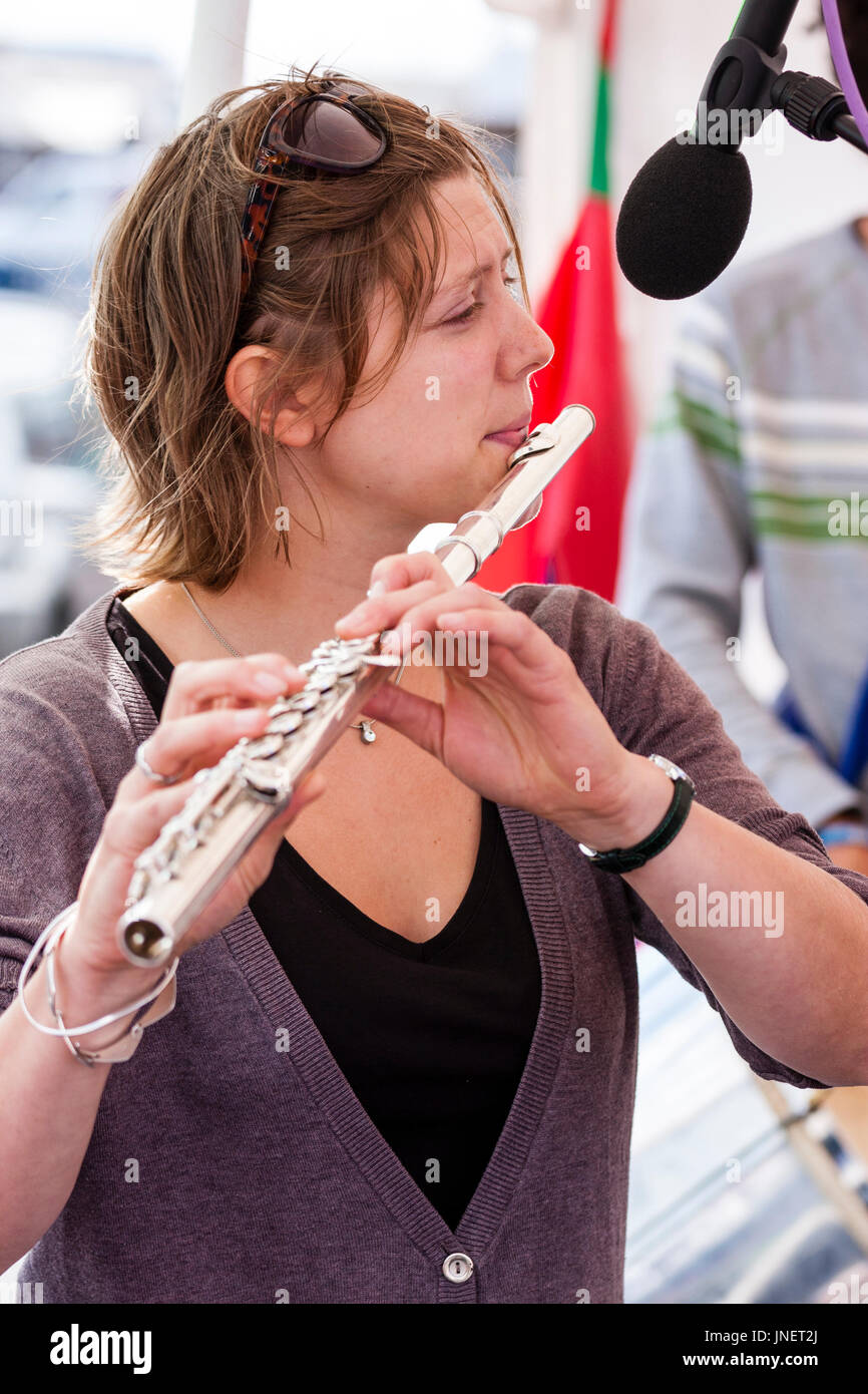 Kurze behaarte kaukasische Frau, 20s, Flöte zu spielen. Seitenansicht, bis zu schließen. Mitglied der Jazz Band Gator Hund Schnapper. Stockfoto