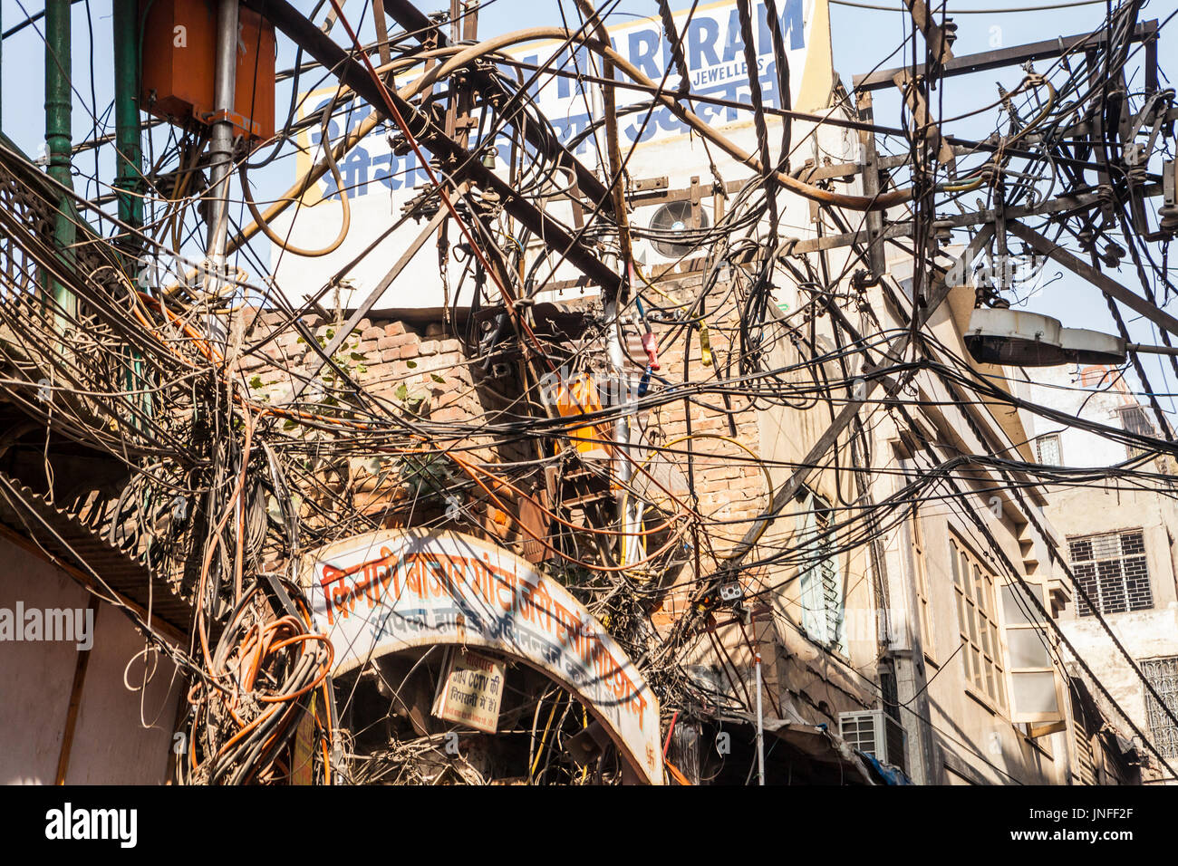 Ein Gewirr von Dienstprogramm Drähten und Kabeln über den Straßen in Chandni Chowk, einem Großmarkt in Alt-Delhi, Indien. Stockfoto