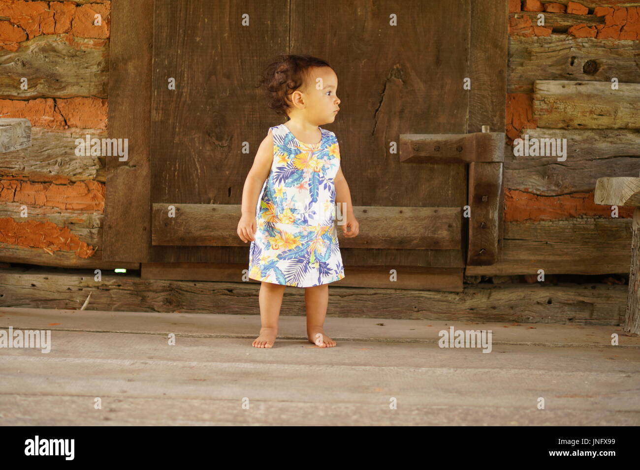 Baby Girl steht vor großen Tür Stockfoto