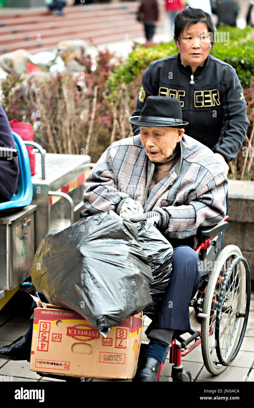 Frau Unterstützung alter chinesischer Mann im Rollstuhl, Peking, China Stockfoto