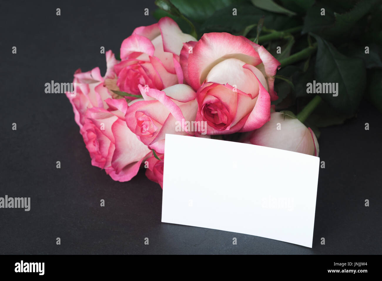 Blumenstrauß aus Rosen und leeren tag mit kopieren. Detailansicht. Muttertag, Frauentag oder andere Feiertage Geschenk mockup Stockfoto