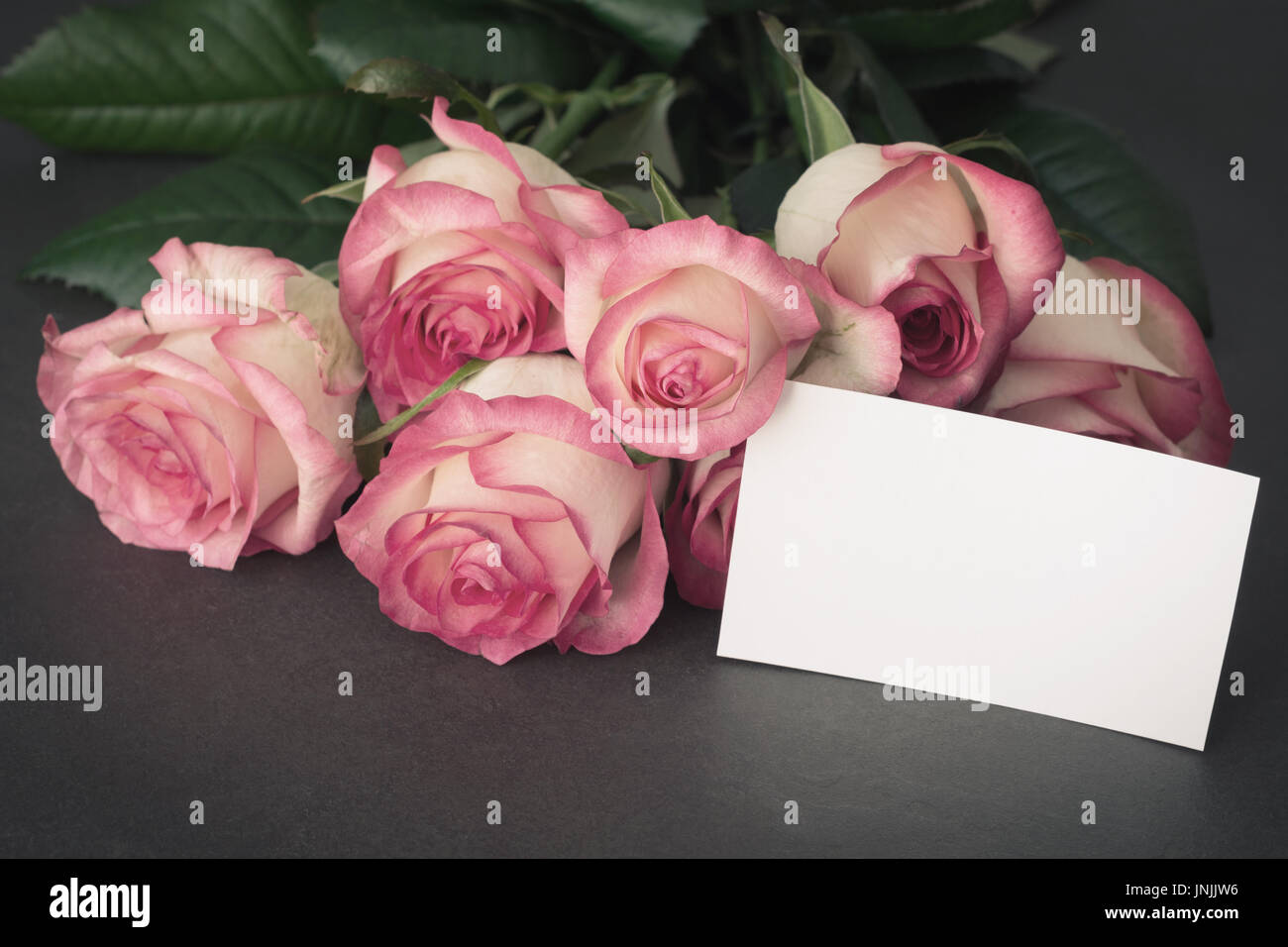 Blumenstrauß aus Rosen und leeren tag mit kopieren. Detailansicht. Muttertag, Frauentag oder andere Feiertage Geschenk mockup Stockfoto