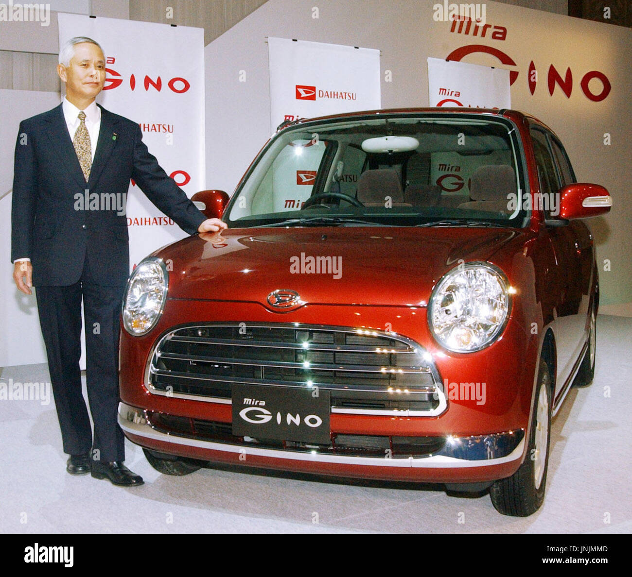 TOKYO, Japan - Daihatsu Motor Co. Präsident Takaya Yamada steht die Firma neue Mira Gino Minivan während einer Präsentation in einem Hotel in Tokio am 29. November. (Kyodo) Stockfoto