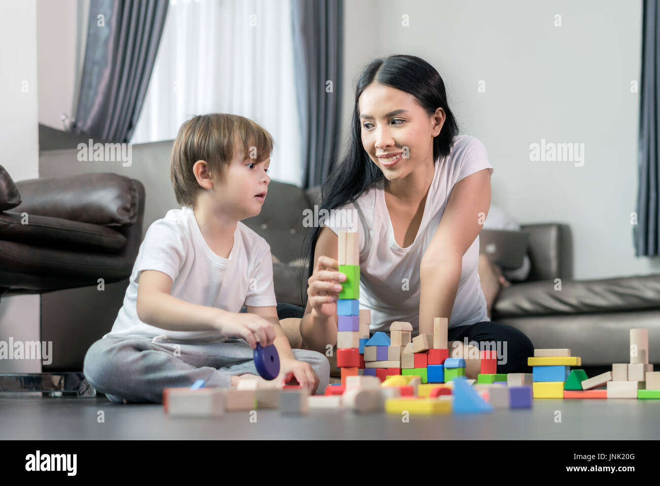 Asiatische junge und Mutter Holz Spielzeug im Wohnzimmer spielen. Glückliche Familie. Stockfoto