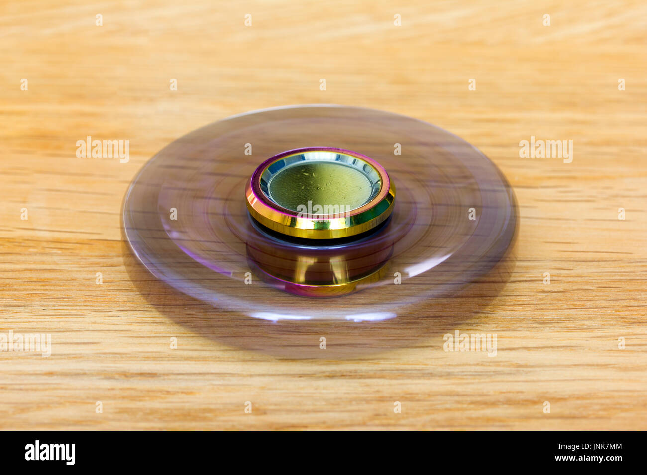 Eine exklusive Fidget Spinner aus Metall wird schnell und liegt auf Holz Stockfoto