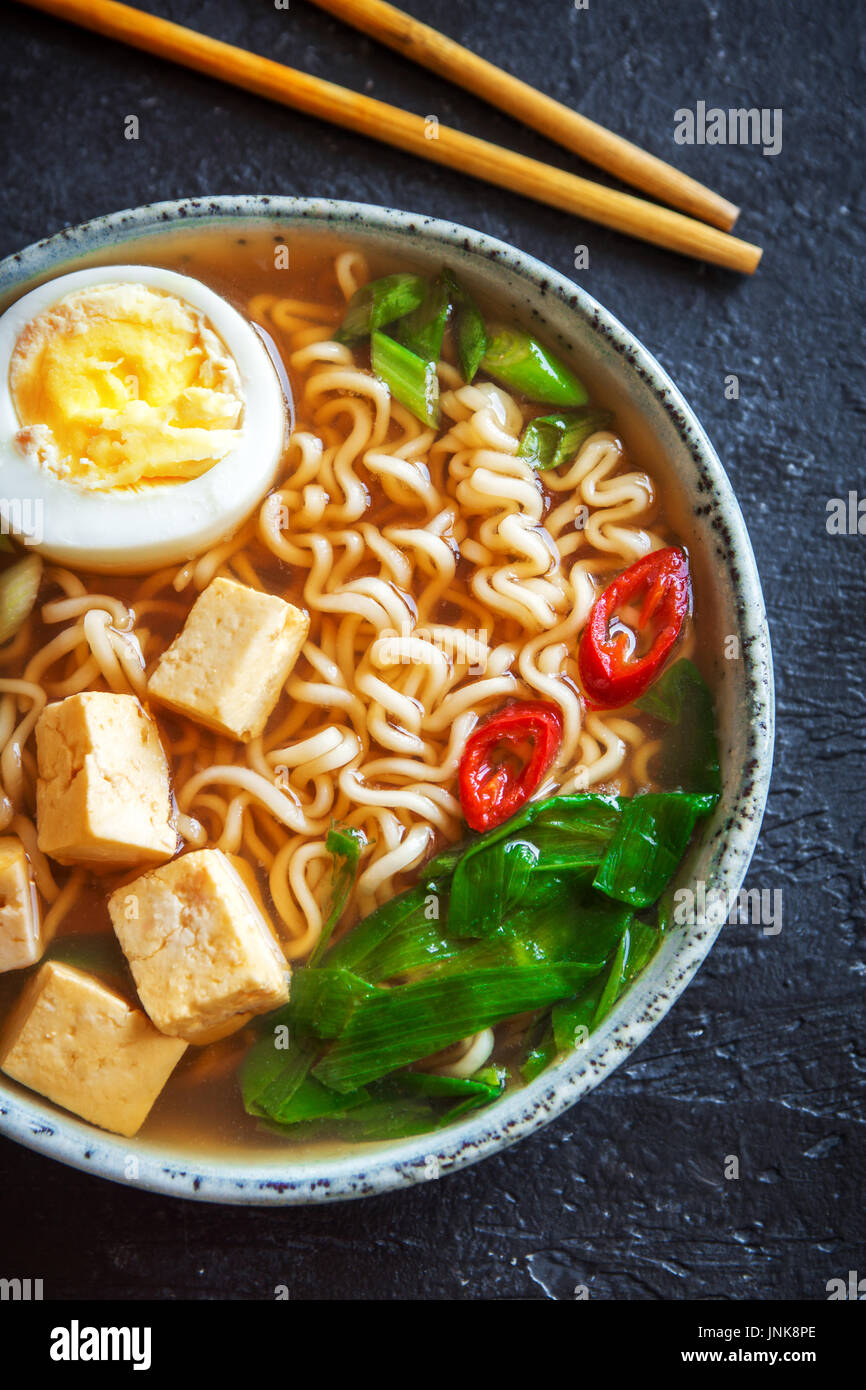 Japanische Ramen-Suppe mit Tofu und Ei auf dunklem Stein. Miso-Suppe ...