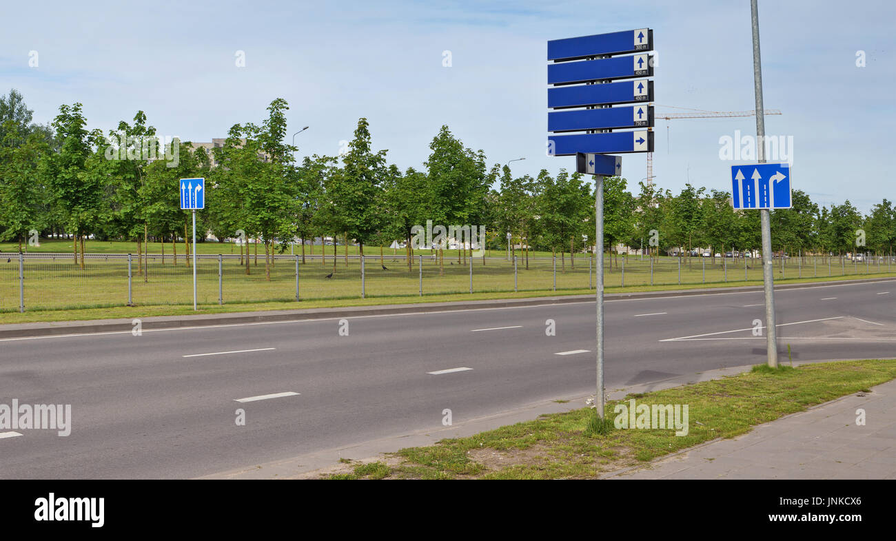 Blaues Licht reflektierende Verkehrszeichen mit weißen Pfeilen befindet sich auf der zentralen Stadt-Autobahn. Nur zwei Fahrspuren - nur gerade, One-Way - t Stockfoto