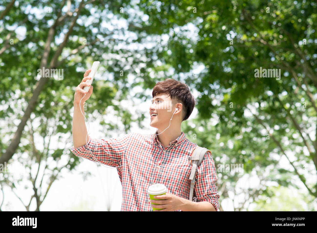 Hübscher junger asiatischer Mann Blick auf Handy Stockfoto