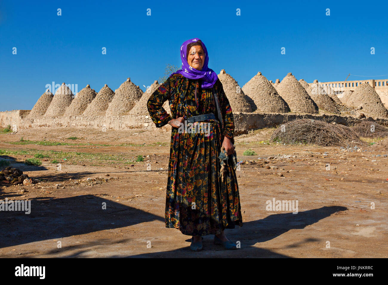 Lokale Frau mit Lehmziegel lehmziegel lehmziegel Häuser im Hintergrund, in der Stadt Harran, Sanliurfa, Türkei. Stockfoto