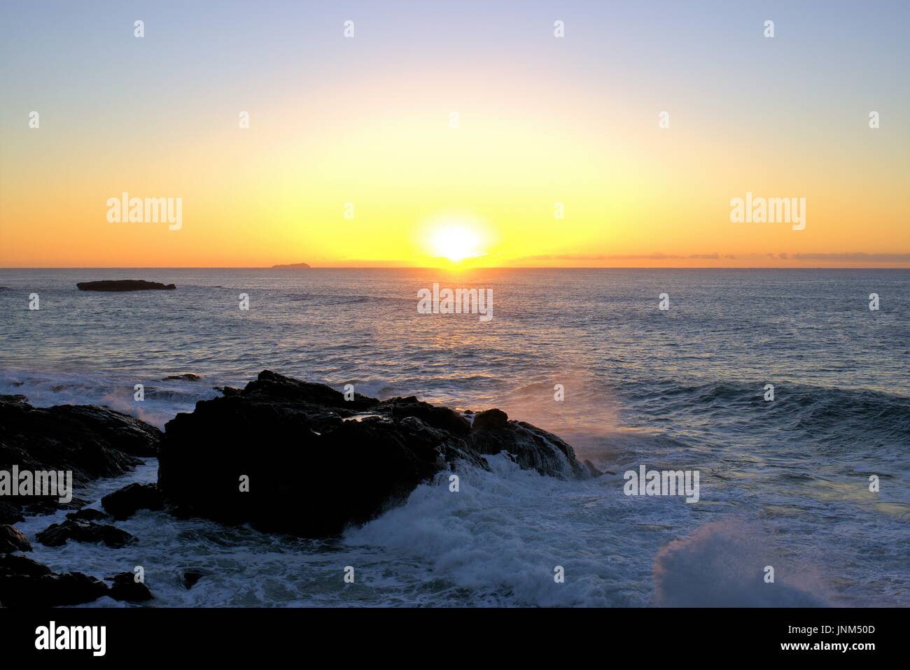 Strand Sunrise Wellen schlagen Felsen. Sonnenaufgang am Küste mit Felsen. Stockfoto