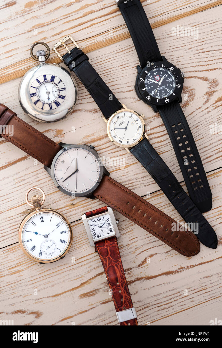 Gruppe von vier Herren Armbanduhren und zwei Tasche Uhren auf einem hölzernen Hintergrund. Stockfoto