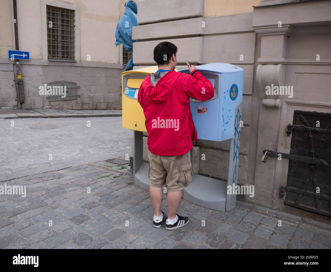 Touristen buchen Postkarte ins Postnord schwedische Post Briefkasten  Stockholm Stockfotografie - Alamy