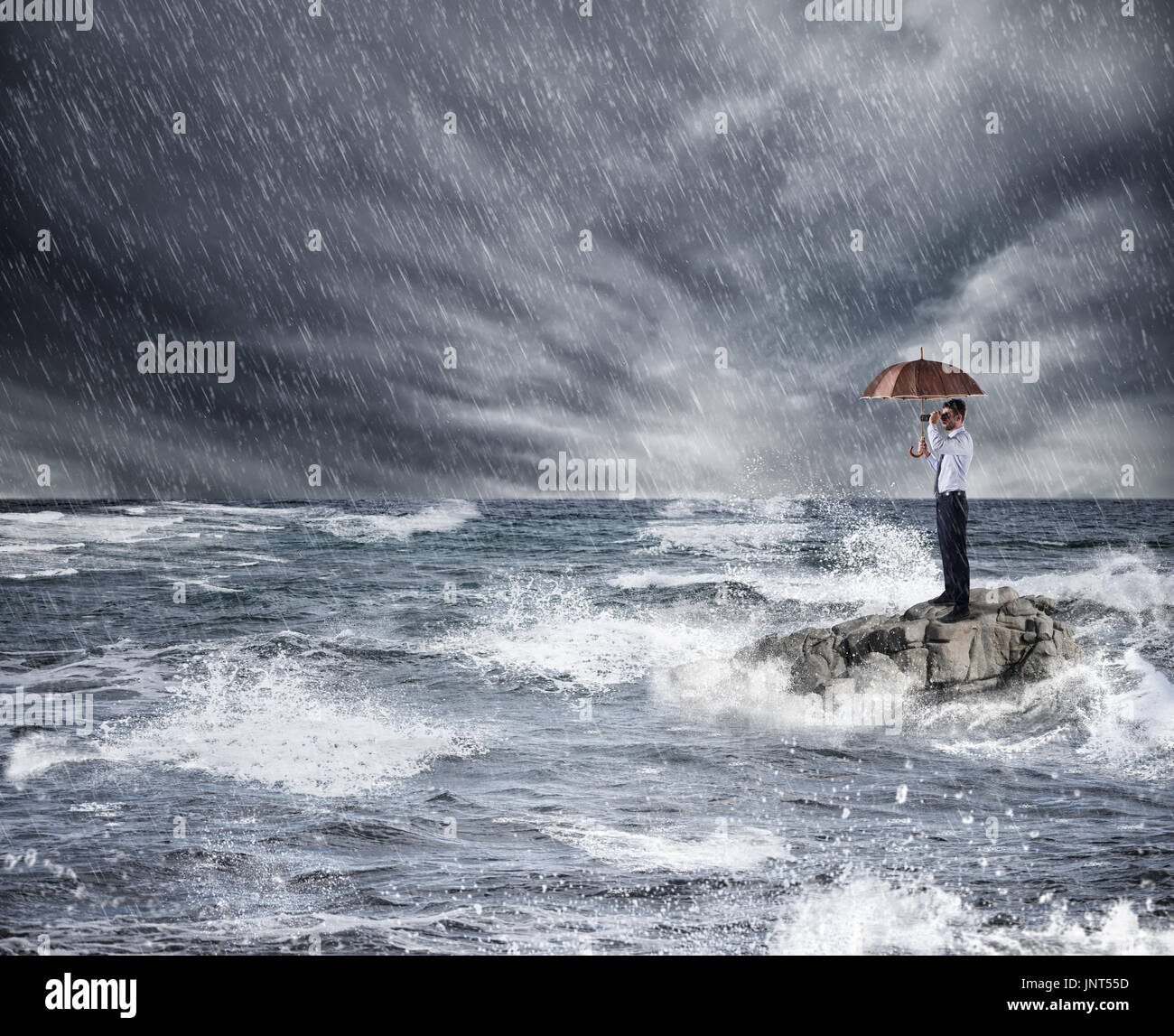 Geschäftsmann mit Regenschirm bei Sturm im Meer. Konzept des Versicherungsschutzes Stockfoto