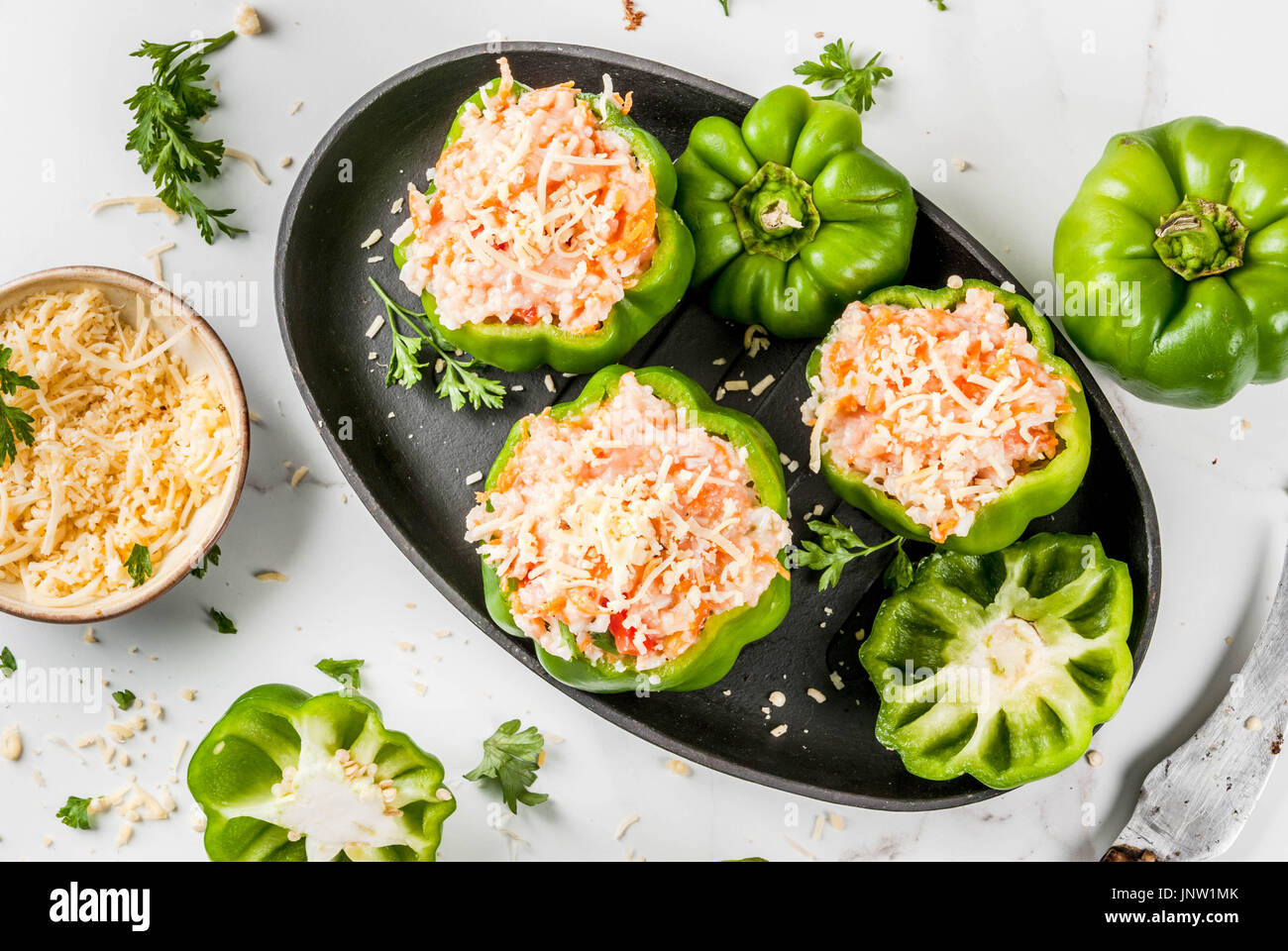 Herbst Rezepte. Haus gefüllte Paprika mit Hackfleisch, Karotten, Tomaten, Kräuter, Käse. Kochvorgang. Weißer Marmor-Tisch. Gefüllte Paprika bereit Stockfoto