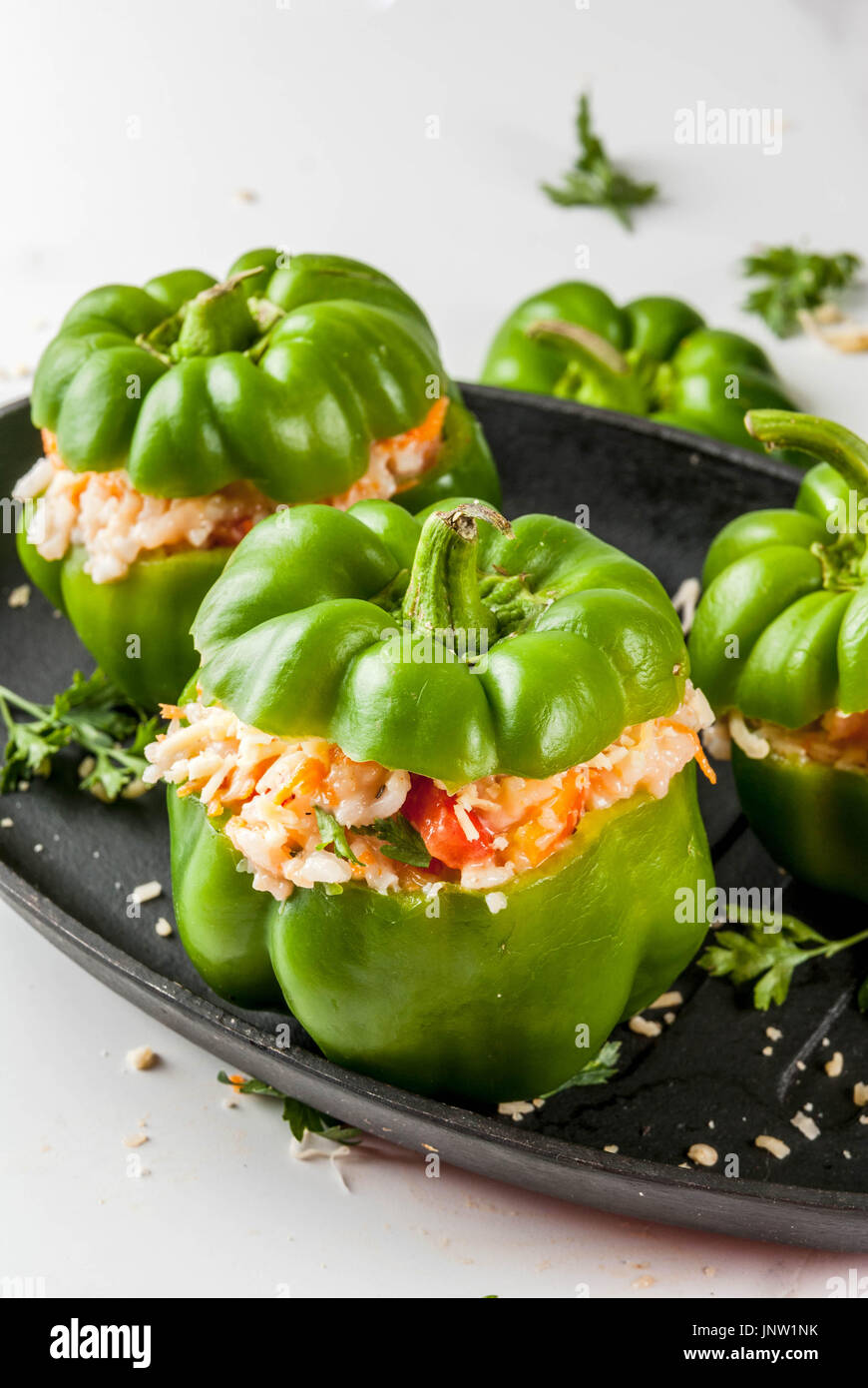 Herbst Rezepte. Haus gefüllte Paprika mit Hackfleisch, Karotten, Tomaten, Kräuter, Käse. Kochvorgang. Weißer Marmor-Tisch. Gefüllte Paprika bereit Stockfoto