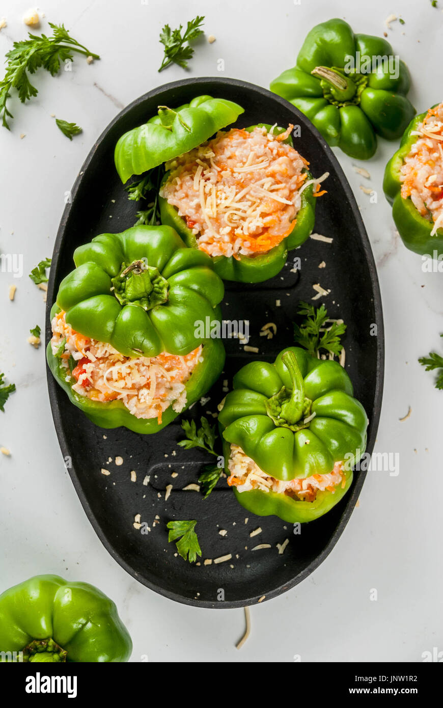 Herbst Rezepte. Haus gefüllte Paprika mit Hackfleisch, Karotten, Tomaten, Kräuter, Käse. Kochvorgang. Weißer Marmor-Tisch. Gefüllte Paprika bereit Stockfoto