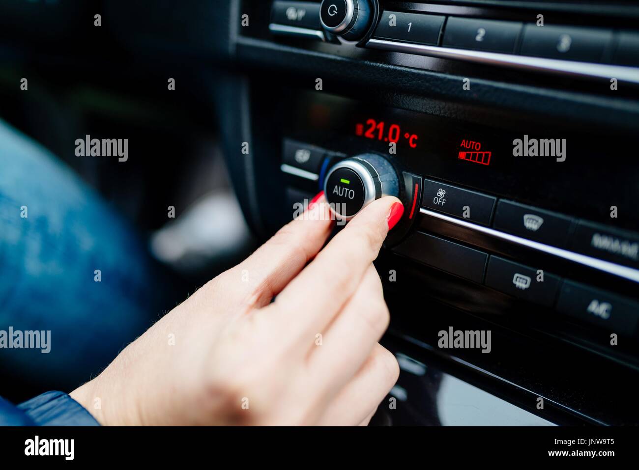 Frau regulierende Auto Klimaanlage. Moderne PKW-Innenraum Stockfoto
