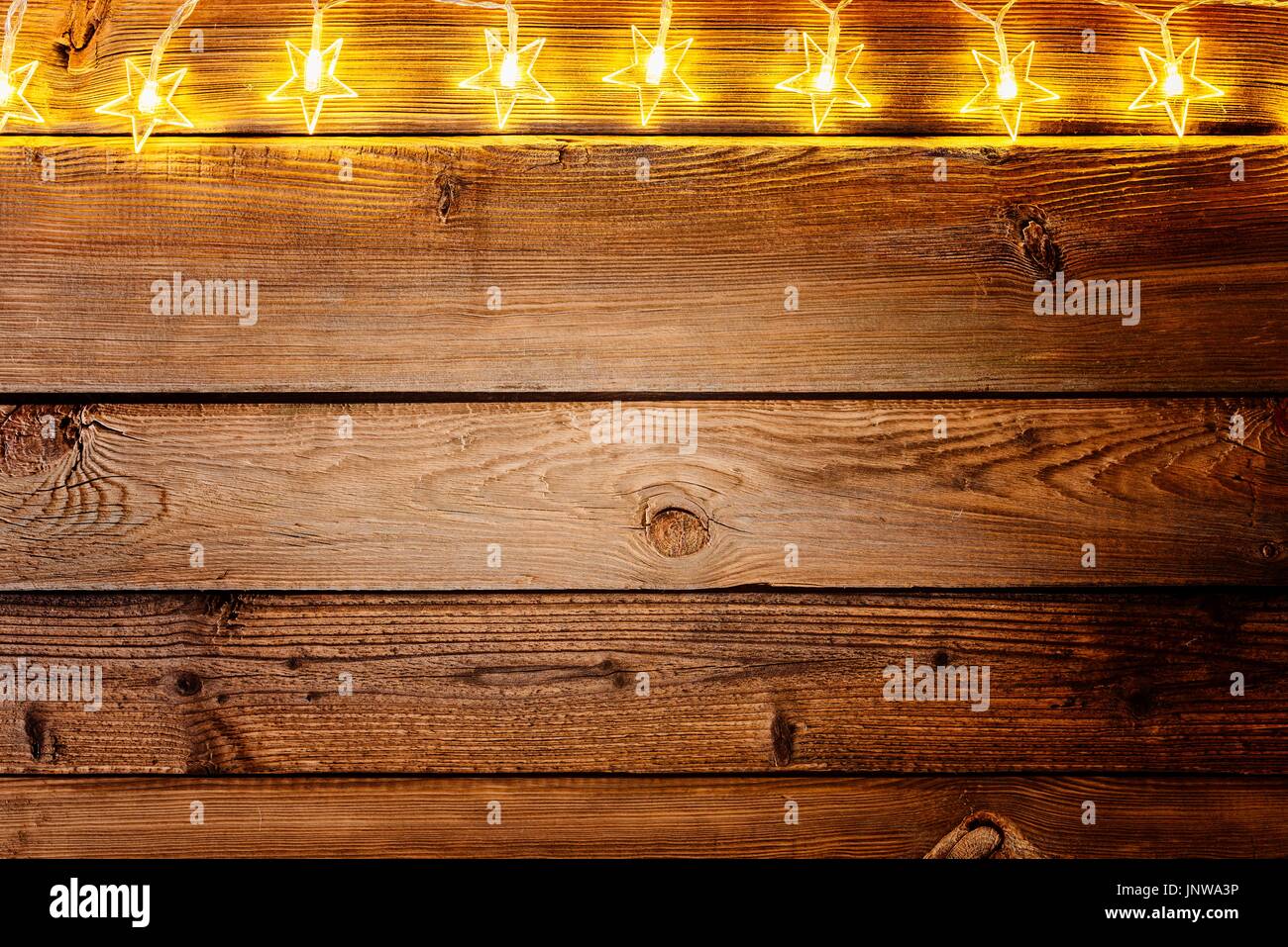 Weihnachtsbeleuchtung auf hölzernen rustikalen Hintergrund. Rahmen der Lichter mit Platz für Text. Frohe Weihnachten Stockfoto