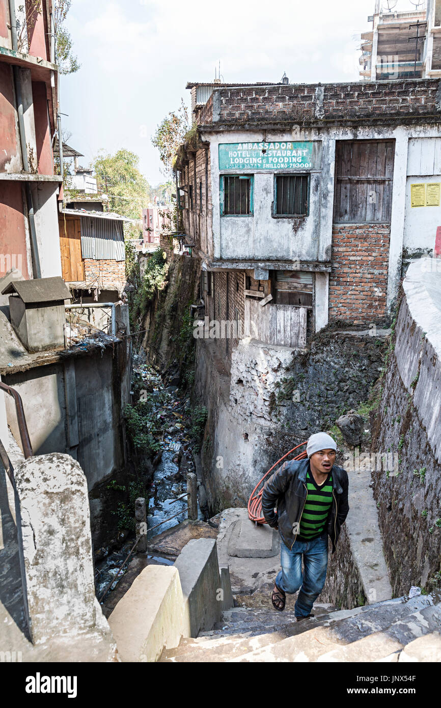 Mann zu Fuß vorbei an schmutzigen suchen Hotel und Unterkunft anmelden Stadt Shillong, Meghalaya, Indien Stockfoto