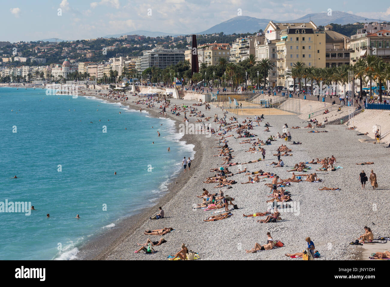 Nizza, Alpes-Maritimes Abteilung, Frankreich - 10. Oktober 2015: Badegäste am Strand von Nizza am Mittelmeer in Alpes-Maritimes, Südosten Frankreichs. Stockfoto