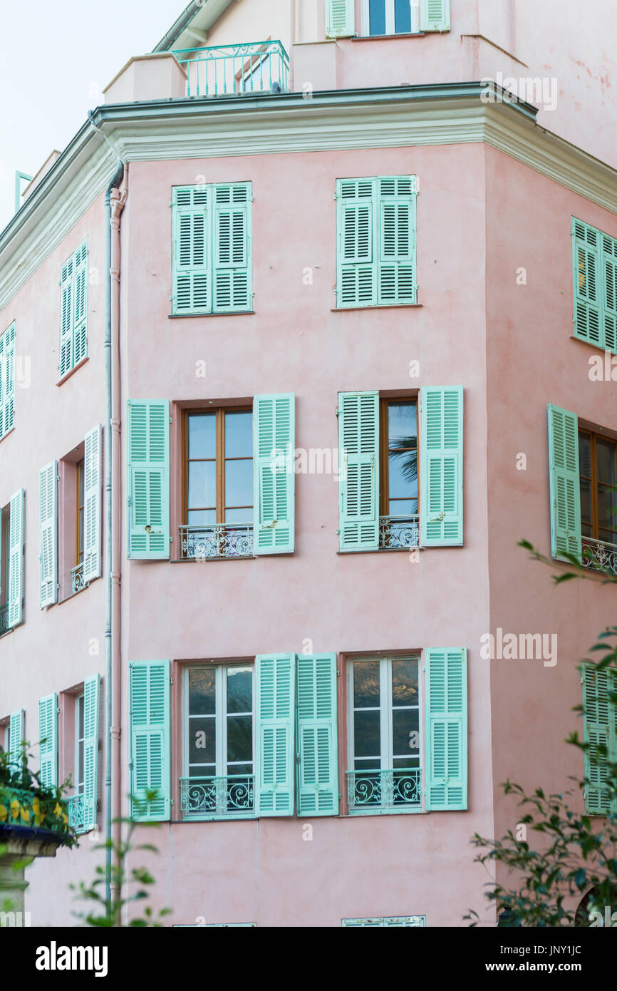 Menton, Alpes-Maritimes, Frankreich-10. Oktober 2015: Typische Wohnhäuser in Pastellfarben mit Rollläden an Fenstern in Menton, Frankreich Südost. Stockfoto