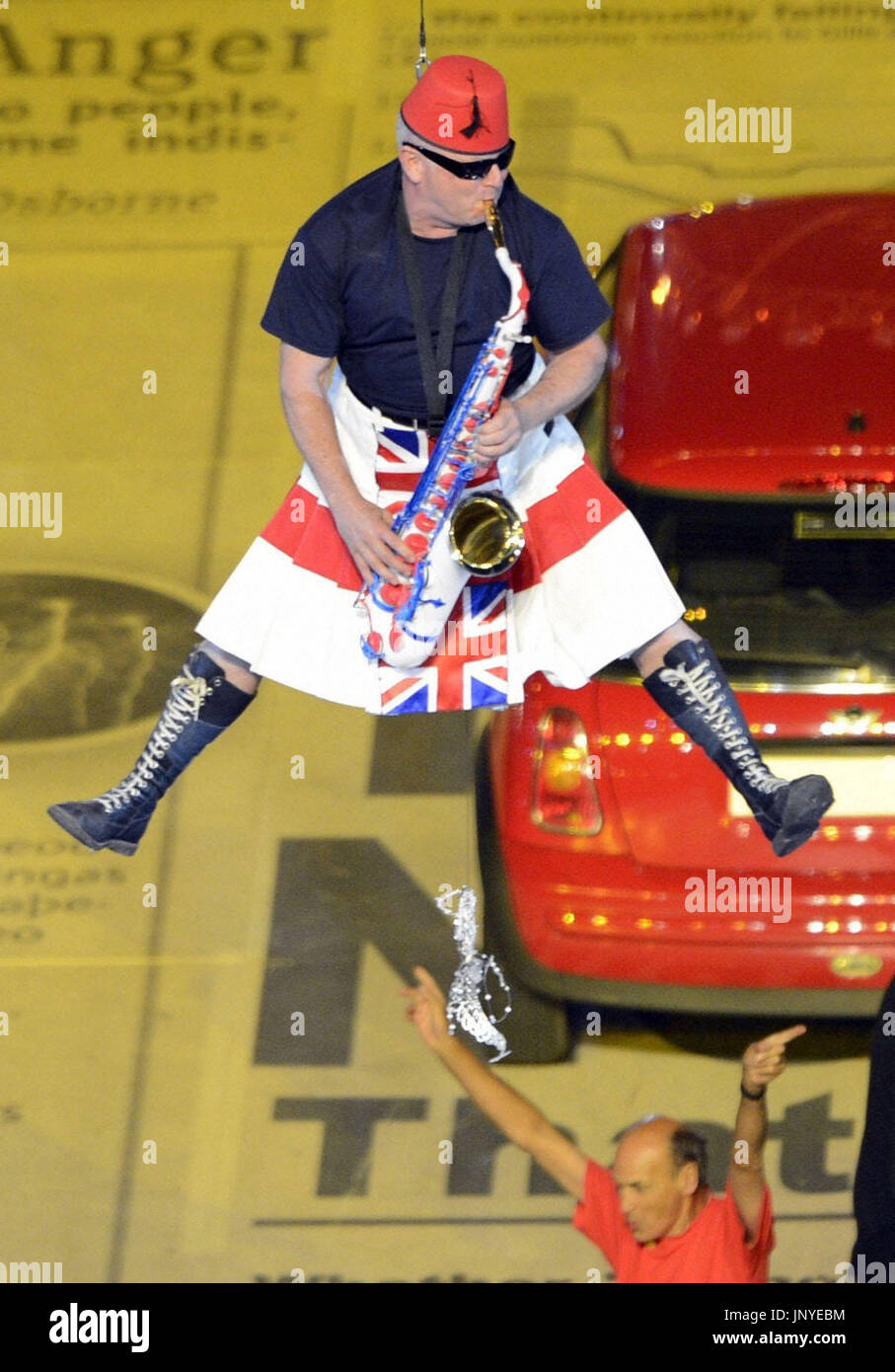 LONDON, Großbritannien - Lee Thompson von der Band Madness schwebt in der Luft, wie er Saxophon bei der Abschlussfeier der Olympischen Spiele in London 2012 im Olympiastadion auf 12. August 2012 spielt. (Kyodo) Stockfoto