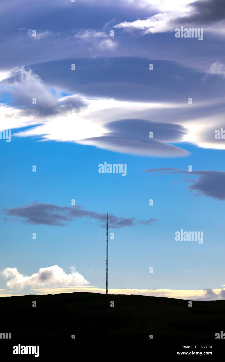 Seltsame Wolken bekannt als linsenförmige Wolken erscheinen über den Moel-y-Parc Mast auf den Hügeln Clwydian Range, Wales Stockfoto