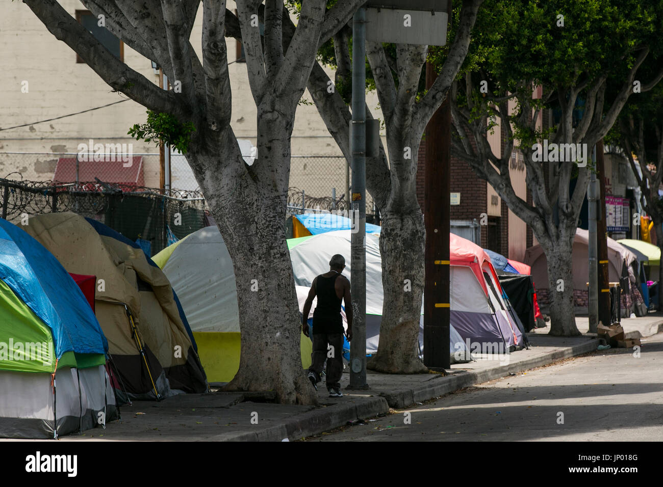 Los Angeles, Kalifornien, USA. 27. Juli 2017. Ein Obdachloser Mann geht vorbei an Zelten auf San Pedro St im Bereich Skid Row von Los Angeles. Bildnachweis: Jonathan Alcorn/ZUMA Draht/Alamy Live-Nachrichten Stockfoto