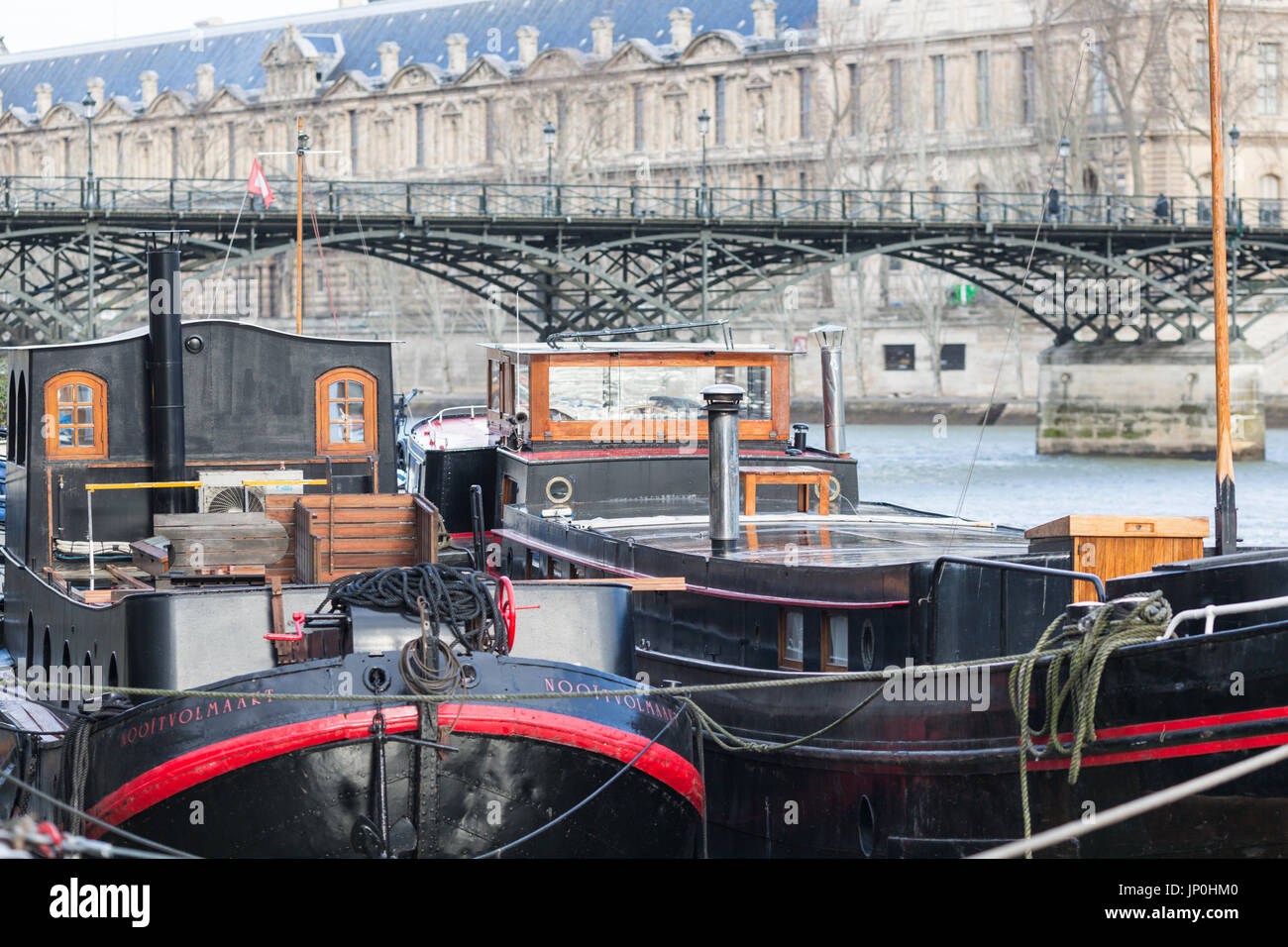 Paris, Frankreich - 2. März 2016: Boote auf der Seine, Pont des Arts und dem Louvre im Hintergrund. Stockfoto