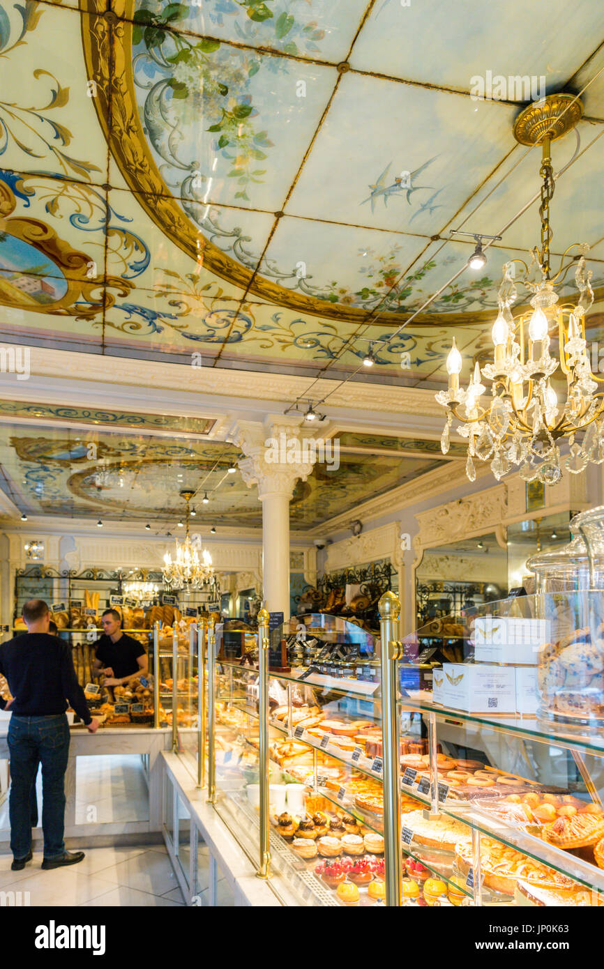 Paris, Frankreich - 2. März 2016: Shop Bedienung und Kunde im Au Petit Versailles du Marais Bäckerei und Konditorei Shop im Marais, Paris. Stockfoto