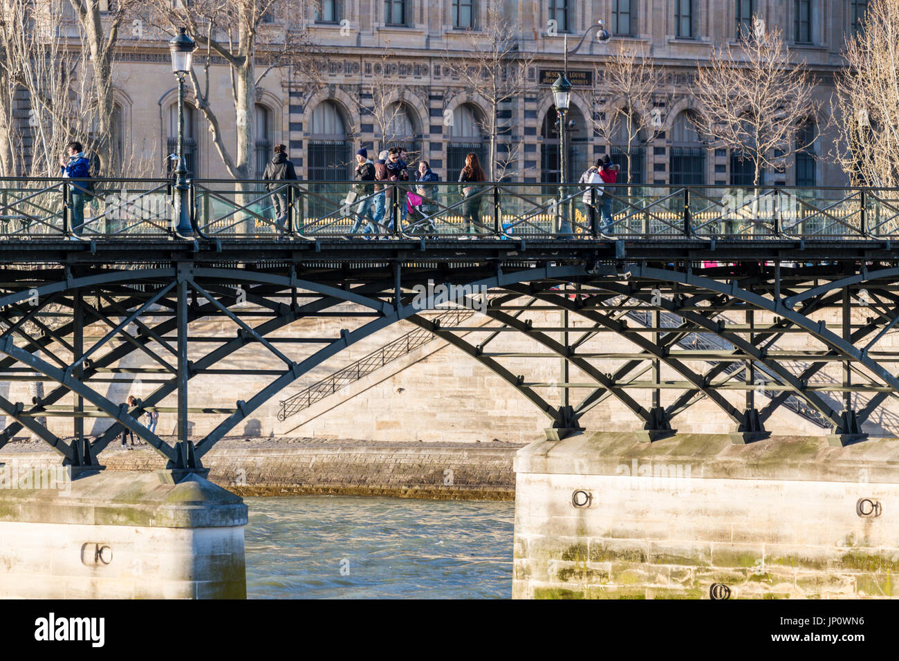 Paris, Frankreich - 3. März 2016: der Pont des Arts und dem Louvre mit Menschen auf der Brücke, Paris, Frankreich Stockfoto