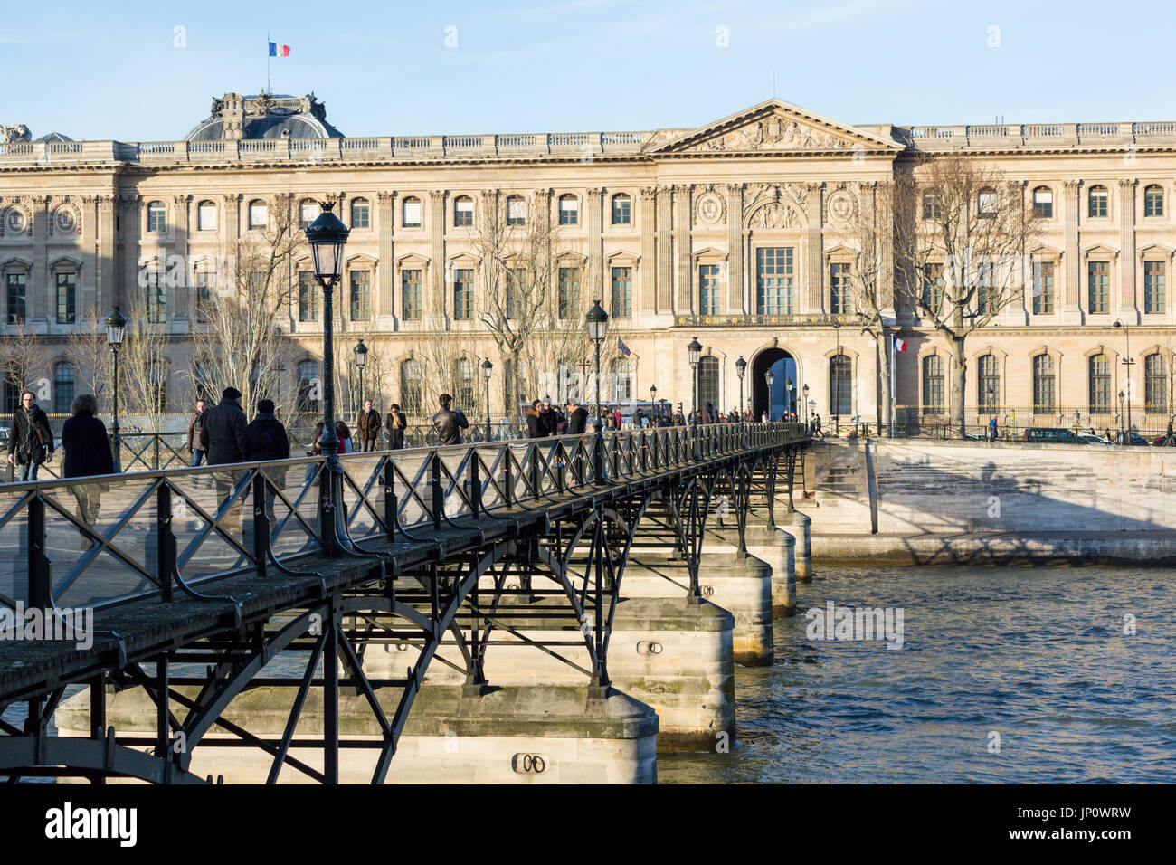 Paris, Frankreich - 3. März 2016: der Pont des Arts und dem Louvre mit Menschen auf der Brücke, Paris, Frankreich Stockfoto