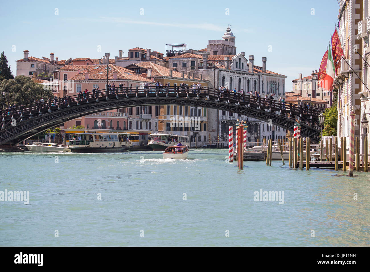 Venedig, Italien - 26. April 2012: Die Accademia-Brücke über den Canal Grande in Venedig. Zwei Vaporettos und einige Wassertaxis sind am Canal Grande. Stockfoto