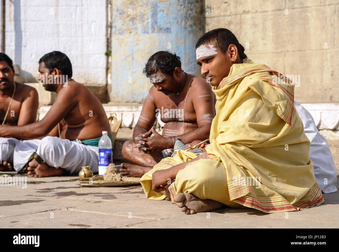 Männer Hommage an verstorbene Verwandte auf den ghats von Varanasi Stockfoto