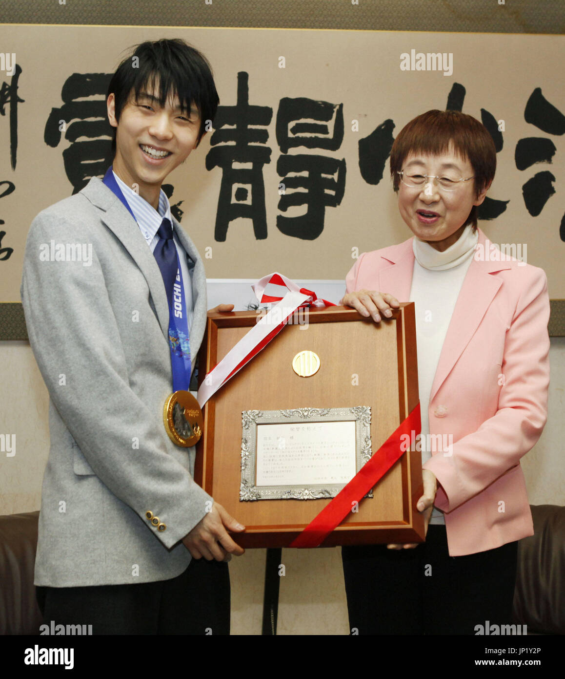 SENDAI, Japan - Sotschi Männer Eiskunstlauf gold Medalist Yuzuru Hanyu (L) erhält ein "Schild Lob" von Sendai Bürgermeister Emiko Okuyama am 26. Februar 2014, im Rathaus für seine Leistung bei den Winterspielen in Russland. Hanyu Erfolg hob die Geister vieler Menschen in Sendai, seiner Heimatstadt, sowie andere Bereiche im Nordosten Japans, die in der März 2011 Erdbeben und Tsunami-Katastrophe verwüstet wurden. (Kyodo) Stockfoto