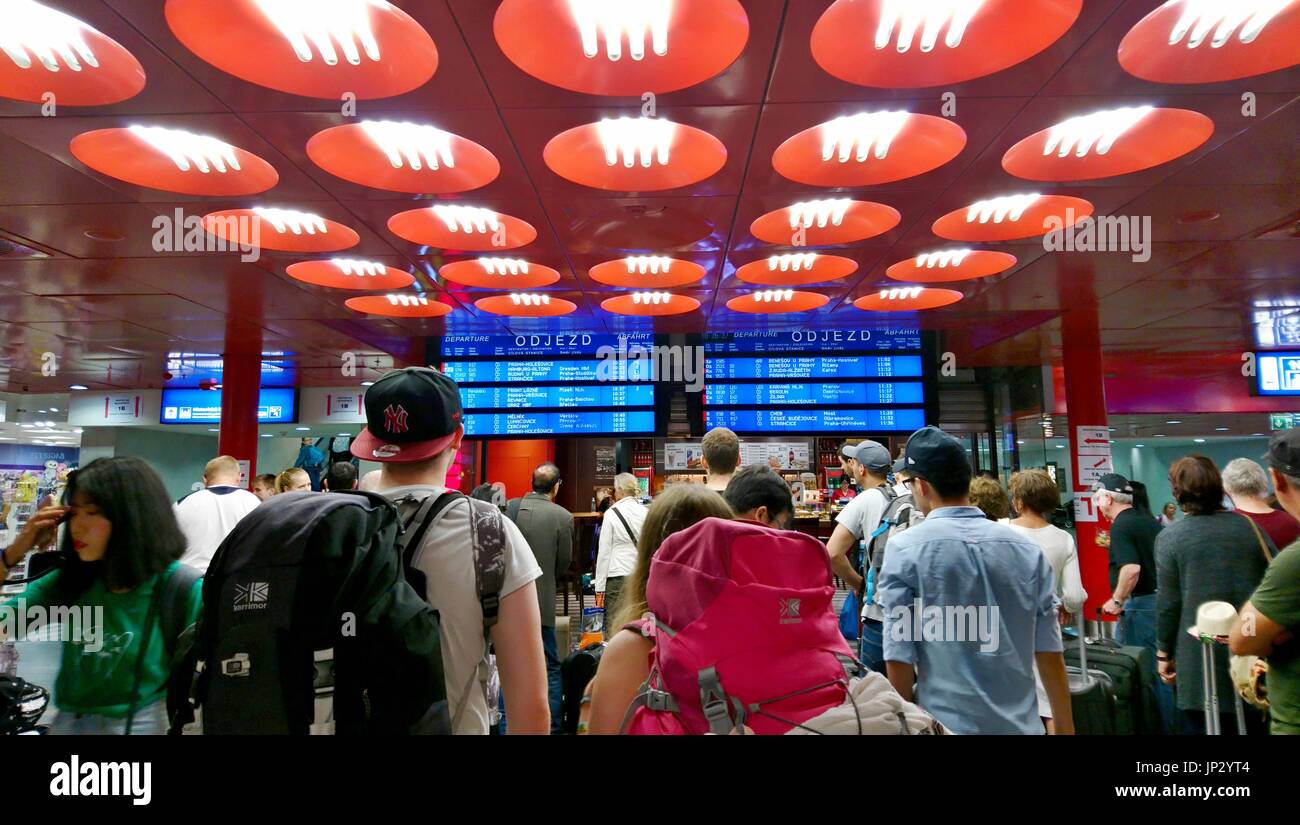 Prag, Tschechische Republik - 28. Juli 2017: Reisende warten auf einen Zug in Abflughalle und blicken auf eine Abfahrtstafel in Prag Hauptbahnhof statio Stockfoto