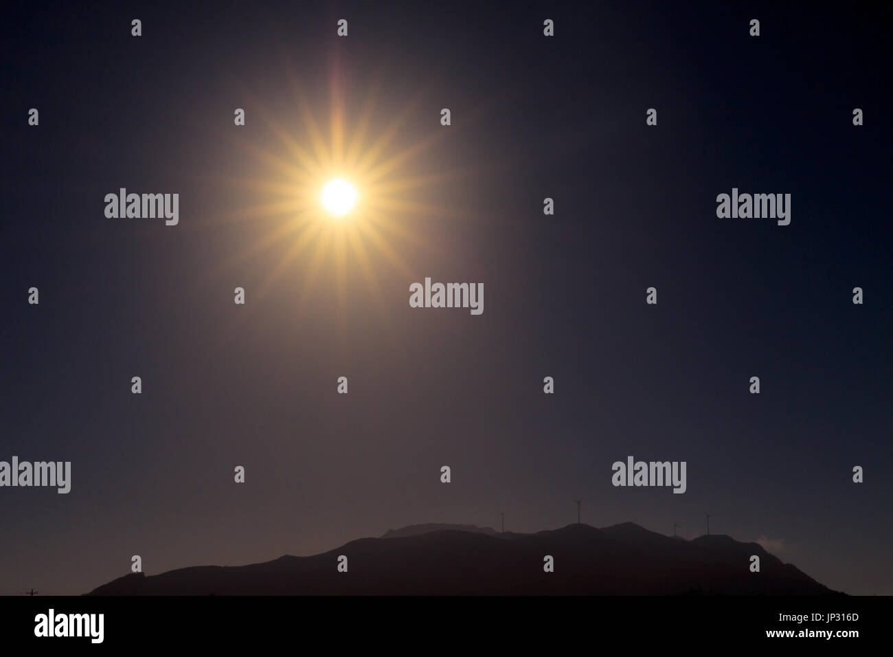 Sonnenblende mit radialen Strahlen über die Spitze des Berges Stockfoto