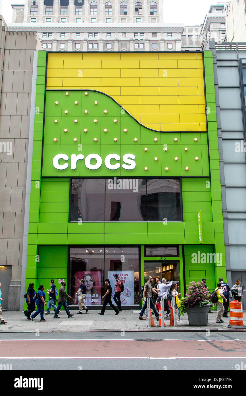 Menschen gehen von einem Crocs store in Manhattan. Stockfoto