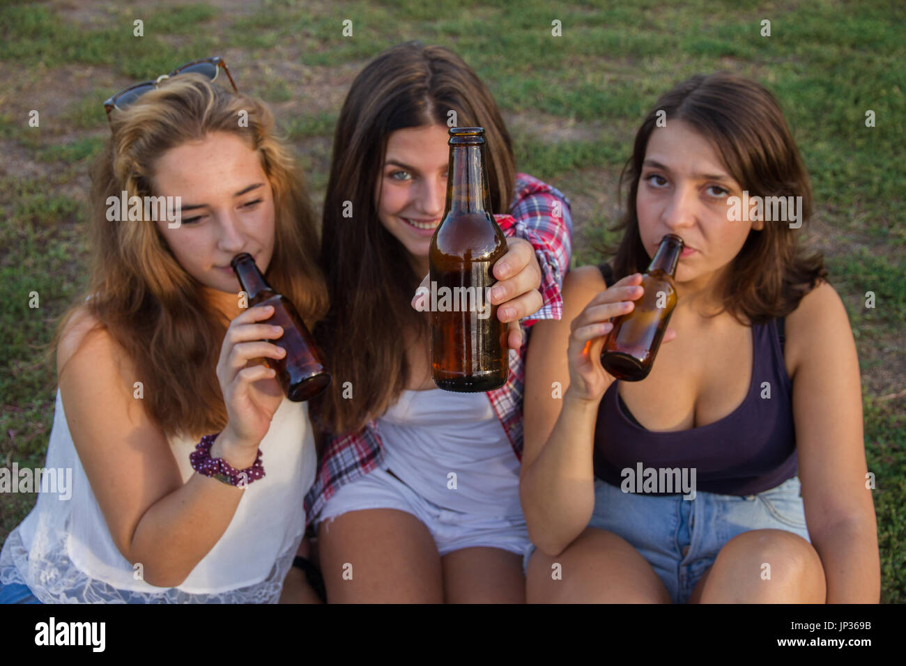 Weibliche Freunde feiern den Urlaub eine gute Zeit Bier trinken in einem Park. Sie sind glücklich. Stockfoto