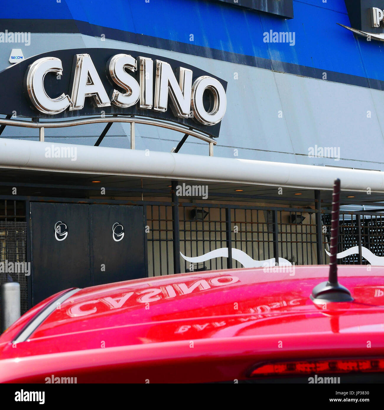 Casino-Zeichen spiegelt sich im Dach ein rotes Auto Stockfoto