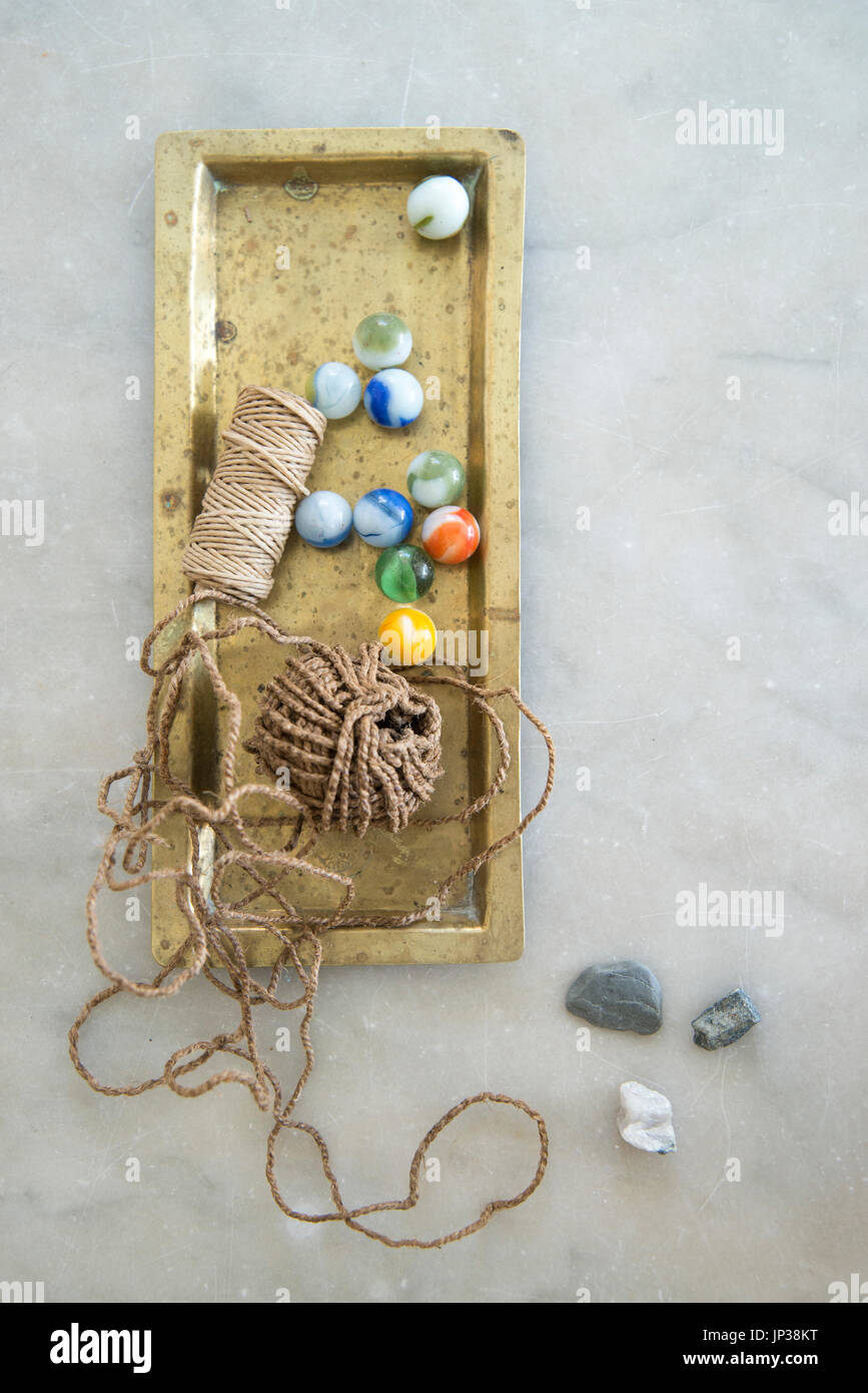 Tablett voller Murmeln und Zeichenfolge und Kids Kollektion Stockfoto